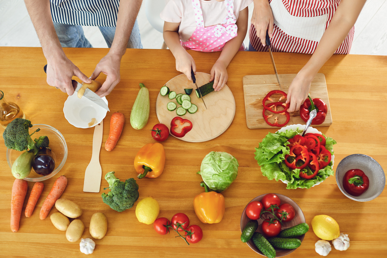 Family Cooks Fresh Vegetables on the Table in the Kitchen.